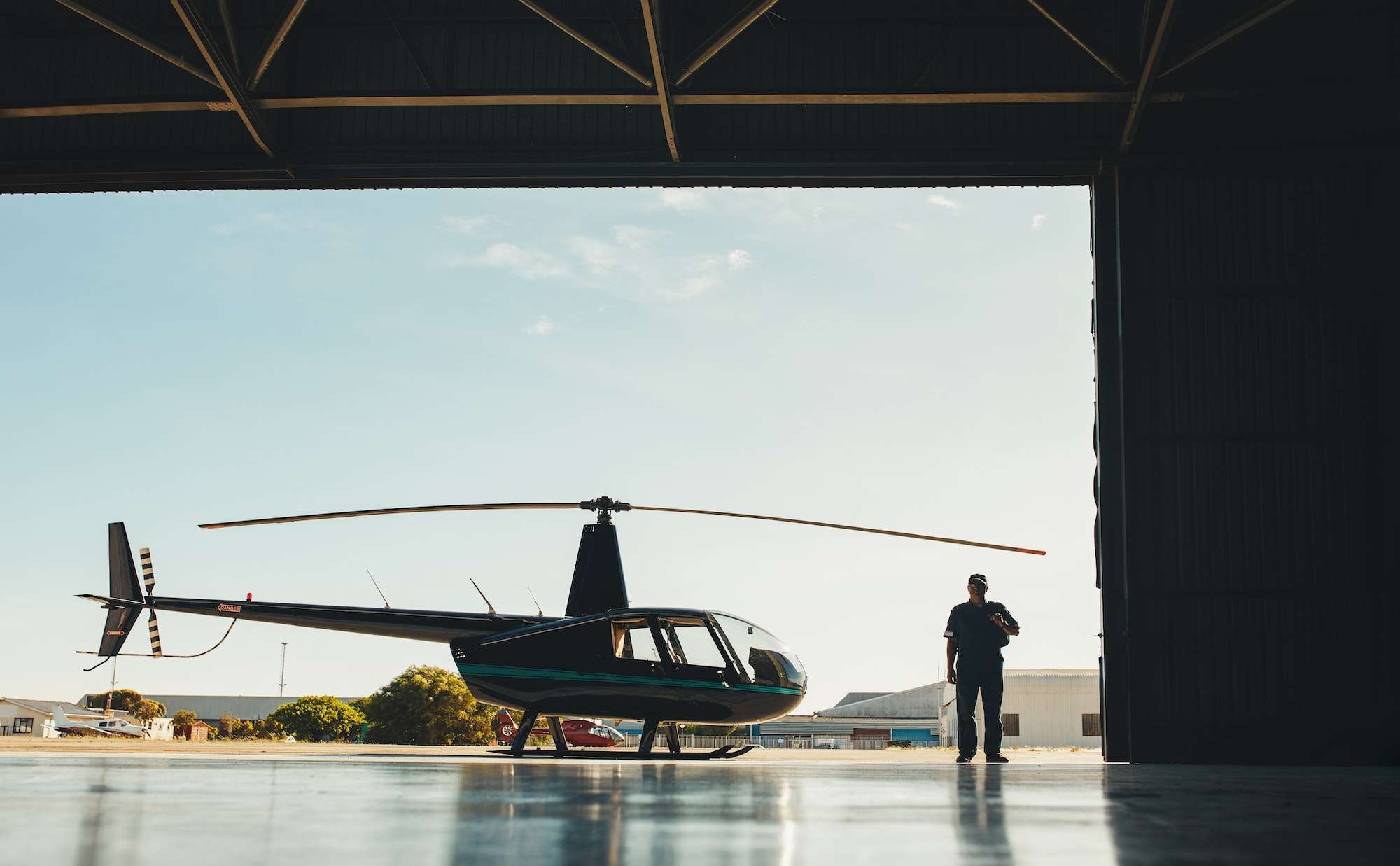 Pilot with a helicopter in airplane hangar